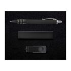 Black ballpoint pen with silver accents, a rectangular black case, and a black USB flash drive with a swivel cover arranged on a textured black surface.