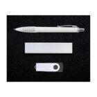 A white ballpoint pen, a rectangular silver box, and a white USB flash drive with a black ring are placed on a black textured surface.