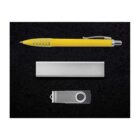 A yellow pen with a silver clip, a silver rectangular object, and a silver USB flash drive with a swivel cover are arranged on a black surface.