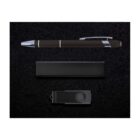 A gift set on a black background features a black pen with silver accents, a rectangular black box, and a black USB flash drive.