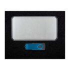 A silver power bank and a blue USB flash drive are placed side by side on a black textured surface.