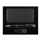 A black gift set on a textured black background, containing a rectangular power bank, a black pen with metallic accents, and a black USB flash drive with a swivel cover.