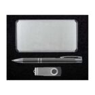 A silver rectangular power bank, a black and silver pen, and a silver USB flash drive are arranged on a black surface.