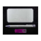 A rectangular silver case, a gray and silver pen, and a purple and black USB drive are set against a black background.