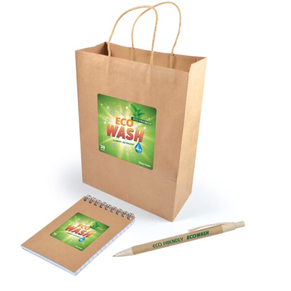 Brown paper bag with Eco Wash branding, featuring a green leaf and water droplet design. A matching notebook and pen with Eco Friendly Eco Wash text are placed nearby. The items convey an environmentally friendly theme.
