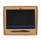 A black writing tablet with a blue trim is placed inside an open cardboard box. A black pen with a blue tip lies beneath the tablet. The packaging is simple and minimalistic.