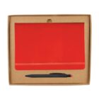 A cardboard box containing a red notebook with an elastic band and a black pen with a red tip. The notebook and pen are neatly arranged within the box.
