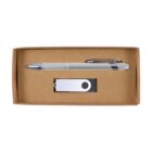 A rectangular cardboard box containing a silver ballpoint pen with a textured grip and a metal clip, alongside a silver USB flash drive with a black circular accent on the swivel cover.