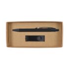 A cardboard box containing a black ballpoint pen with a silver clip and a black USB flash drive. The items are set against a plain brown background inside the box.