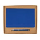 A blue notebook with an elastic band is placed in a cardboard box along with a matching blue pen. The pen has a silver clip and tip. The background is plain white.