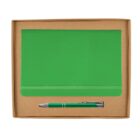 A green notebook and a matching pen are neatly placed inside a brown cardboard box. The notebook has a horizontal elastic band, and the pen is silver with a green body, positioned horizontally below the notebook.