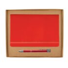 A brown cardboard box containing a red notebook with an elastic closure and a red pen with silver accents. The notebook and pen are neatly aligned within the box.