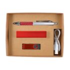 A cardboard gift box containing a red and silver pen, a red portable charger, a red USB flash drive, and a white USB charging cable.