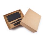 Open cardboard gift box containing a black notebook, a pen, and a USB flash drive. The items are neatly arranged inside the box, and the lid is partially open, showcasing the contents against a white background.