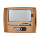 A boxed gift set containing a rectangular metal business card holder, a silver pen with a textured grip, and a gray USB flash drive with a swivel cover, all neatly arranged inside a brown cardboard box.