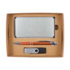 A gift set in a brown box containing a silver business card holder, an orange and silver pen, and a silver and black USB flash drive.