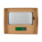 A brown cardboard box containing a rectangular silver power bank and a green USB flash drive. The power bank is placed above the USB drive, both resting in cutouts within the box.