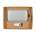 A cardboard box containing a silver rectangular object and a USB flash drive with a swivel cover.