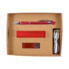 A brown box containing a red pen, a red rectangular power bank, a red USB flash drive, and a white USB cable.