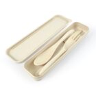 A beige reusable cutlery set inside an open rectangular case. The set includes a spoon, fork, and knife, all matching the cases color and material.