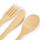 Close-up of eco-friendly bamboo cutlery set featuring a fork, knife, and spoon. The fork and knife have a smooth, light wood texture, while the spoon displays a gently curved, polished surface, highlighting the natural grain of the bamboo.