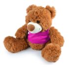 A fluffy brown teddy bear wearing a bright pink top sits upright against a white background, looking slightly to the side.