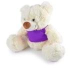 A fluffy white teddy bear wearing a purple vest sits with its legs spread and arms slightly forward. The bear has a light brown nose and a friendly expression. The fur looks soft and plush.