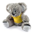A plush koala toy wearing a bright yellow shirt sits with its arms and legs spread out. The toy has soft, fluffy gray fur and large, rounded ears. Its nose and eyes are prominently black, giving it a cute and cuddly appearance.