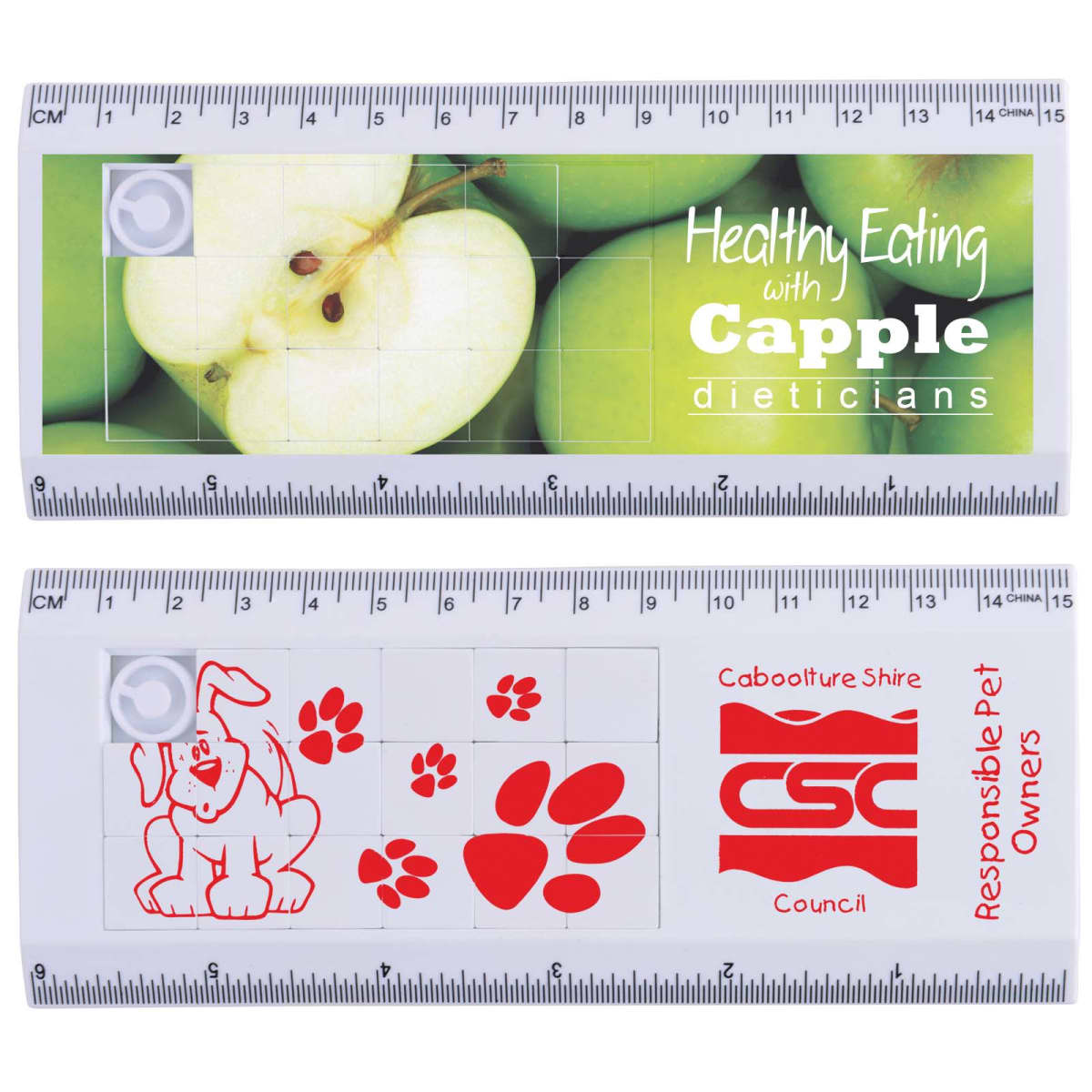 Two 15cm rulers with sliding puzzles. The top ruler features an image of apples with the text Healthy Eating with Capple Dieticians. The bottom ruler displays a red logo, a dog, and paw prints, with the text Responsible Pet Owners Caboolture Shire Council.