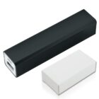 A black rectangular power bank with a USB port, placed alongside a white box. The power bank has a simple and minimalist design.