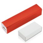 Red rectangular portable power bank next to a white rectangular box on a plain background. The power bank has a USB port on one end.