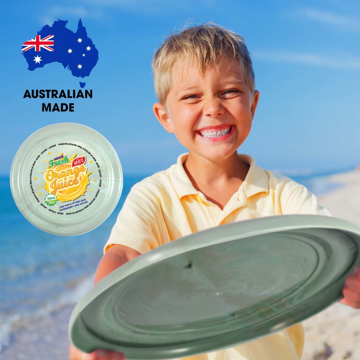 A smiling child in a yellow shirt holds a green frisbee on a beach. The frisbee has a label for fresh orange juice and an Australian flag map icon with the text Australian Made is in the upper left corner.