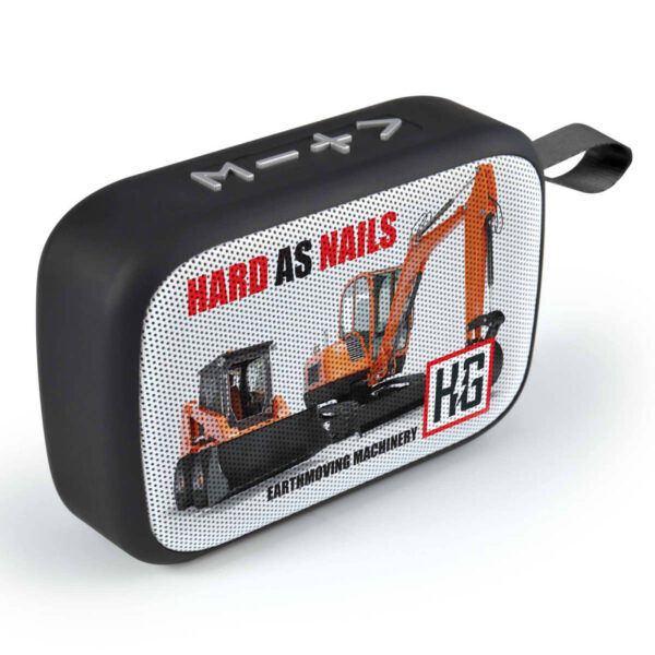 Rectangular black speaker with a graphic of an excavator on the front, alongside the text HARD AS NAILS and EARTHMOVING MACHINERY. A logo with the letters HB is in the lower right corner. A small loop is on the upper right edge.