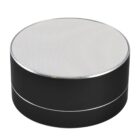 A compact, round wireless speaker with a metallic grille on top and a sleek black body. It has a silver trim around the edge, giving it a modern and stylish look.