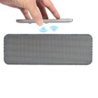 A hand holds a smartphone above a rectangular wireless speaker. Blue signal waves are illustrated between the phone and the speaker, indicating a connection, possibly via Bluetooth or another wireless method.