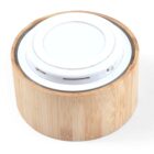 A round wireless charger with a bamboo outer casing and a white charging pad on top. It has a USB port on the side for connection. The design is minimalist and eco-friendly, combining natural materials with modern technology.