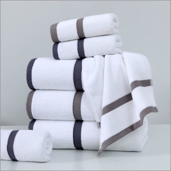 A stack of white towels with gray and black striped borders is neatly arranged on a white surface against a light gray background.
