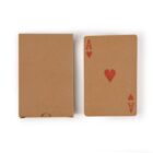 Playing card with red heart ace beside a brown card box.