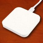 White square wireless charger on a wooden surface.