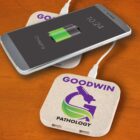 Smartphone charging on branded wireless charger labeled GOODWIN PATHOLOGY.