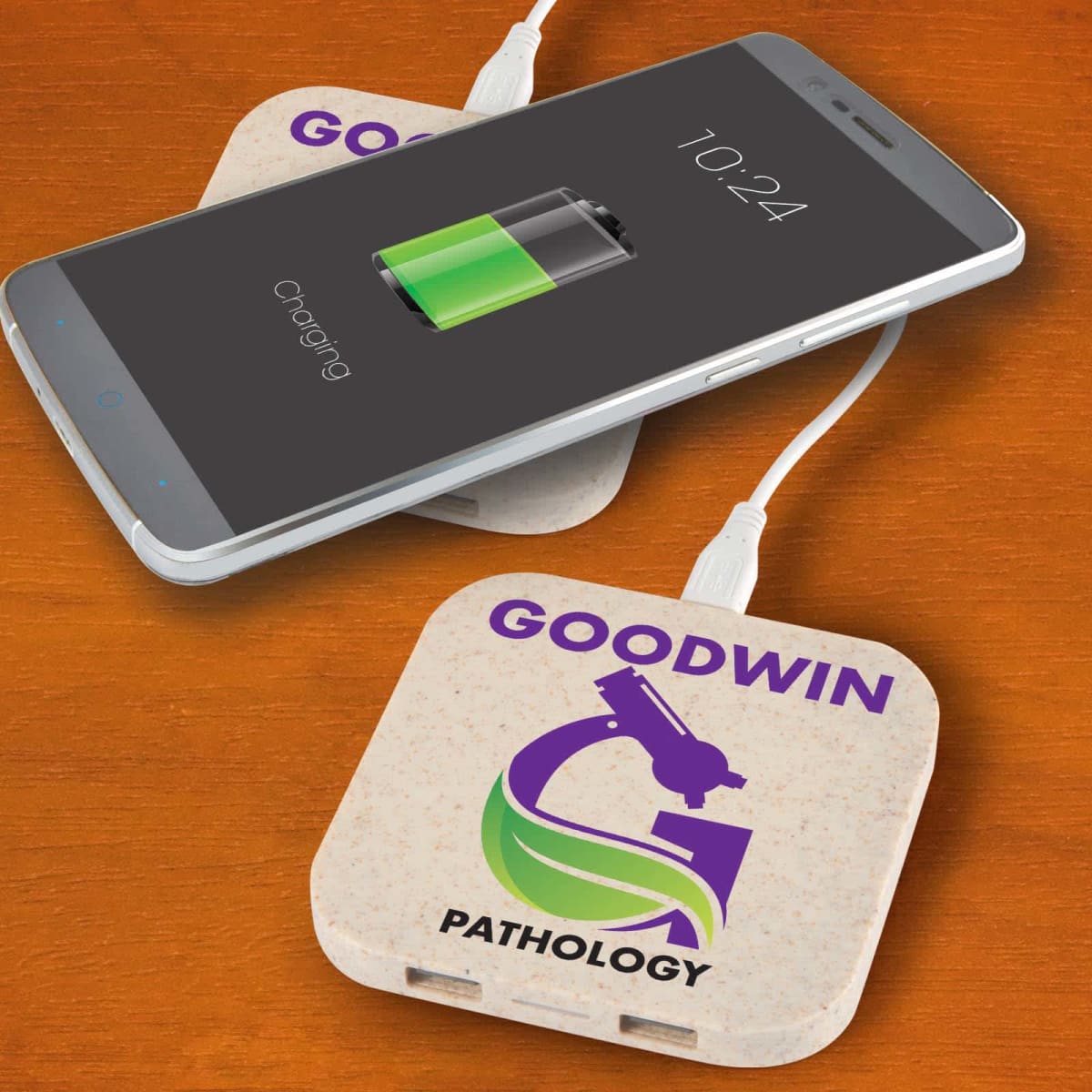 Smartphone charging on branded wireless charger labeled GOODWIN PATHOLOGY.