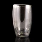 Clear double-walled glass tumbler on a reflective black surface.