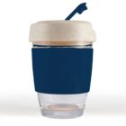 Reusable coffee cup with a navy blue sleeve and a beige lid featuring a closed spout.