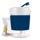Reuseable cup with a lid, blue band, and a snack bag of colorful candies beside it.
