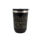 Black insulated tumbler with gold food design and Eat & Co. text.