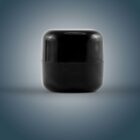 A small, glossy black container with a rounded lid against a gradient background.