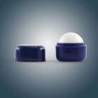 Open blue lip balm container with lid removed, revealing white balm inside.