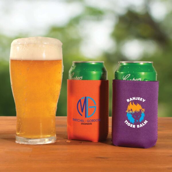 A pint of beer and two canned drinks in koozies on a wooden table.
