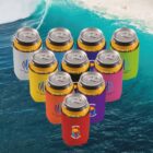 Colorful drink cans with sleeves, arranged in a triangle, over an ocean wave background.