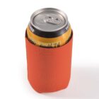 A beverage can in an orange foam koozie.
